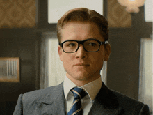 a man in a suit and tie with glasses on