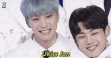 two young men are smiling for a picture and one of them is named ukiss jun .