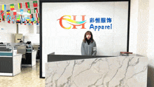 a woman stands in front of a sign that says apparel