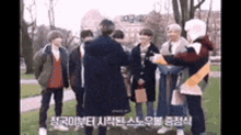 a group of young men are standing in a park .