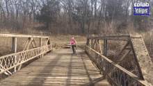 a woman in a pink shirt is riding a bike on a wooden bridge with the words collab clips in the background