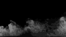 there is a lot of smoke coming out of the bottom of the image on a black background .