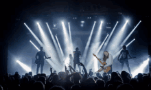 a woman playing a guitar in front of a crowd of people at a concert