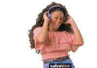 a woman wearing headphones and a pink off the shoulder top with salonline on the bottom