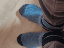 a person wearing a pair of blue and black socks on a wooden floor