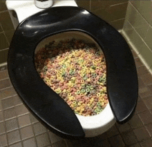 a toilet seat filled with cereal rings in a bathroom