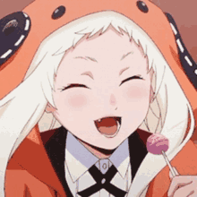 a girl with white hair is holding a lollipop and wearing an orange hoodie .