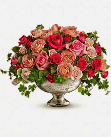 a silver vase filled with pink roses and greenery