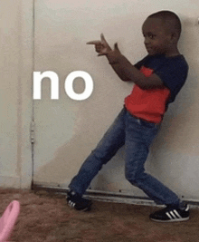 a young boy is pointing at a door with the word no written on it