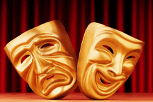 two gold comedy and tragedy masks on a red curtain background