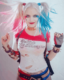 a woman dressed as harley quinn is wearing a daddy 's lil monster t-shirt