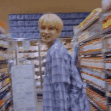 a man is walking through a grocery store aisle .