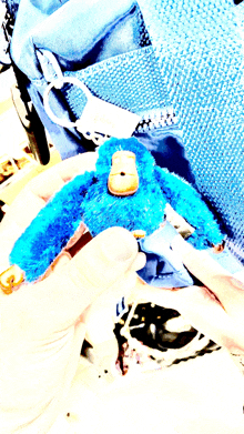 a person is holding a blue stuffed monkey with a yellow face