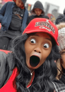 a woman wearing a red hat that says louisville carroll