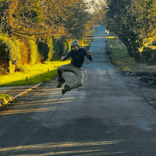 a man is jumping in the air on a street