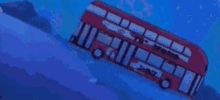 a red double decker bus is going down a hill in the water .