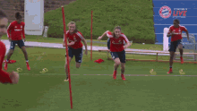 a group of soccer players are running on a field in front of a banner that says fc bayern live