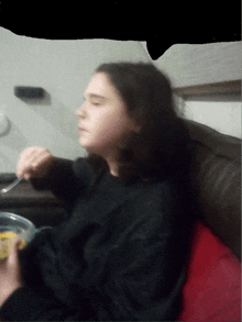 a blurry picture of a person sitting on a couch eating