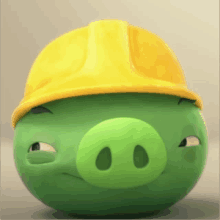 a green pig wearing a yellow hard hat is making a funny face