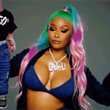 a woman with pink and green hair is wearing a bikini top and a necklace that says nicki minaj .