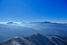 a view of a mountain range with a blue sky and clouds .