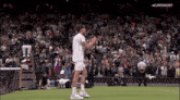 a tennis player stands on a court in front of a crowd with eurosport written on the bottom of the screen