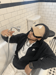 a man wearing a la hat is laying in a bath tub