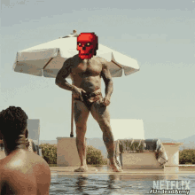 a man in a bathing suit is standing in a pool with a pixelated skull on his face