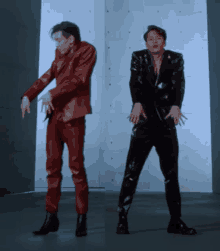 a man in a red suit is dancing next to another man in a black suit