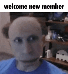 a bald man in a blue shirt with the words welcome new member written above him