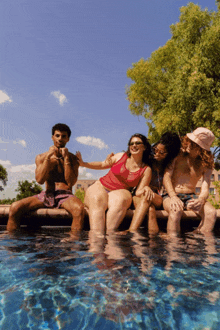 a group of people are sitting in a swimming pool