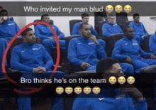 a group of basketball players are sitting in a stadium and one of them is talking