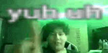 a man is giving a middle finger in front of a green background with the word youth written in white letters .