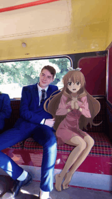 a man in a suit is sitting next to a girl in a pink dress