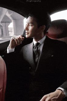 a man in a suit and tie is sitting in a car