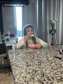 a little girl sits at a counter with a sign that says merry cheer on it