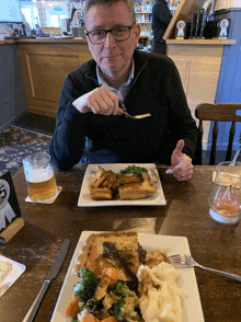 a man sits at a table with a plate of food and a sign that says ' 5 ' on it