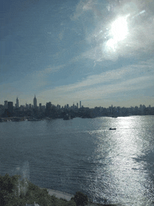 the sun shines brightly over a body of water with a city in the background