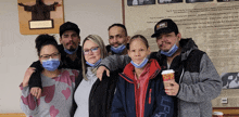 a group of people posing for a picture with one wearing a jacket that says lcg