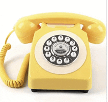 a yellow telephone with the words greeting on the dial