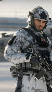 a man in a military uniform has a british flag patch on his chest