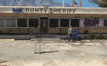 a man is walking in front of a county sheriff 's office