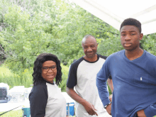 a man in a blue polo shirt is standing next to a woman and a boy