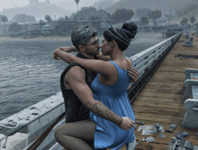 a man and a woman are hugging on a pier