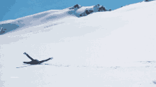 a person laying on their back in the snow with a mountain behind them