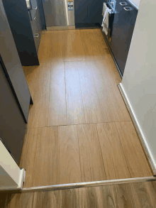 a kitchen with a wooden floor and a stainless steel appliance