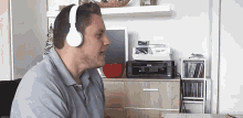 a man wearing headphones is singing in front of a printer