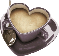 a cup of coffee in the shape of a heart with a spoon .