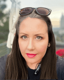 a woman with gray hair wearing sunglasses and a pair of earbuds that say ' bose ' on them