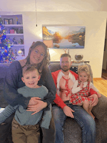 a family posing for a picture in front of a painting of mountains